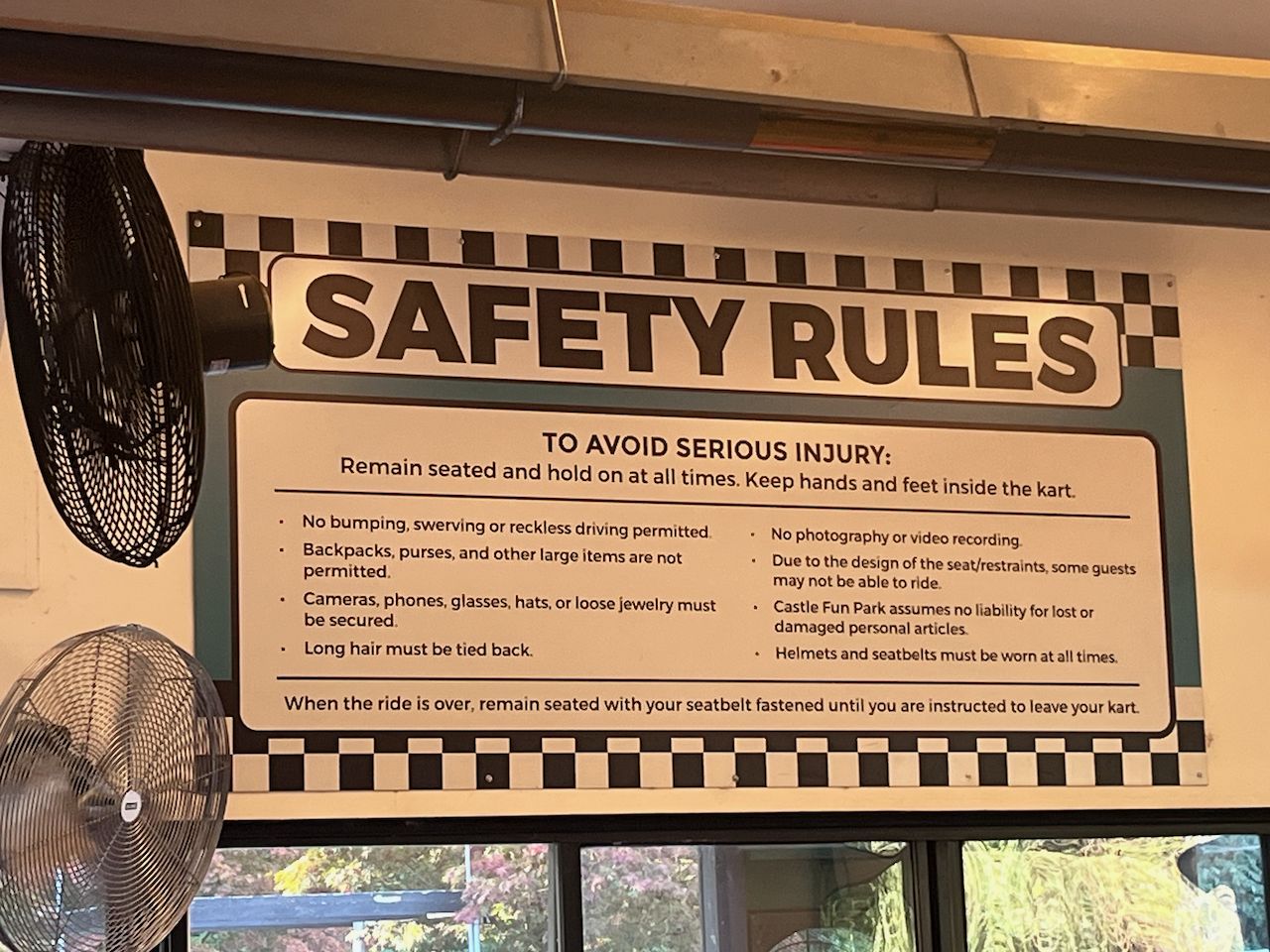 캐슬 펀 파크 고카트 탑승장에 걸린 SAFETY RULES 안내판. 착석 유지, 손발 카트 안에 두기, 헬멧과 안전벨트 착용 등 안전 수칙이 영어로 적혀 있다